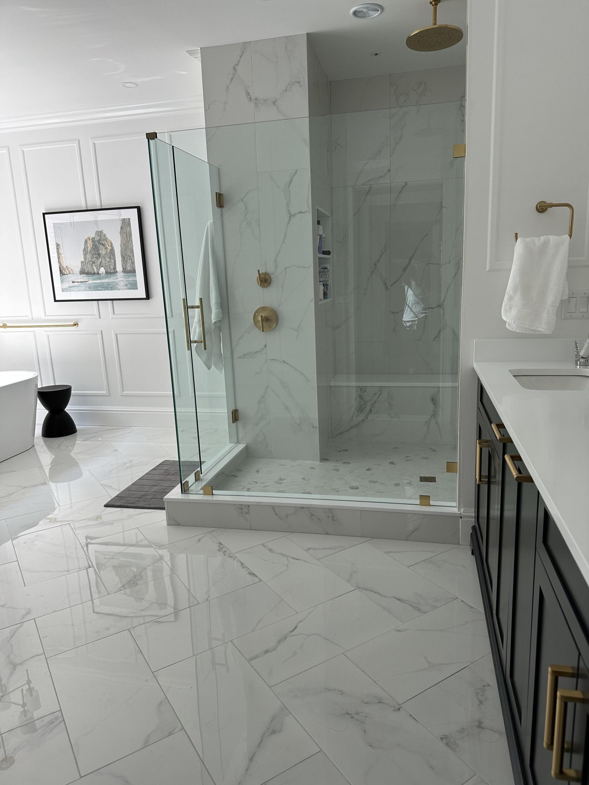 Products featured: 12x24 Lustre Calacatta Polished set on a herringbone, 24x48 Lustre Calacatta Polished, 24x48 Shower walls, and 2x3 Hex Carrara Hex Matte niche. Joe Limiero in our West Hartford showroom.