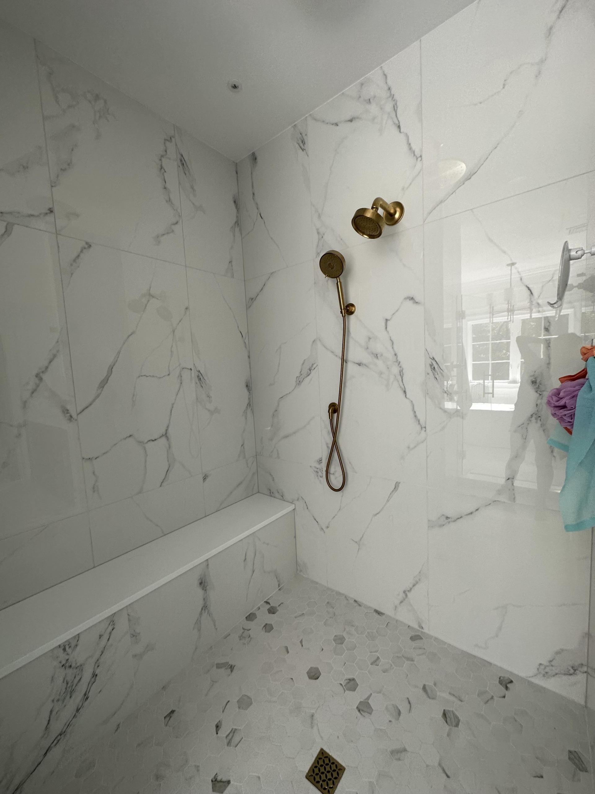 Products featured: 12x24 Lustre Calacatta Polished set on a herringbone, 24x48 Lustre Calacatta Polished, 24x48 Shower walls, and 2x3 Hex Carrara Hex Matte niche. Joe Limiero in our West Hartford showroom. 