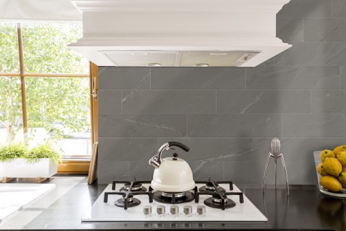 Atlantic stone porcelain tile backsplash near cooktop with white tea kettle.