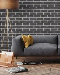 Modern living room featuring Royal Thin Brick charcoal brick veneer wall tile by Metropolitan Ceramics behind a grey sofa.
