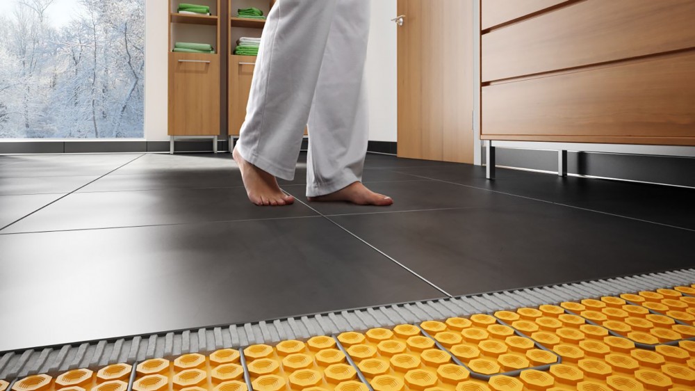 Schluter Ditra Heat floor heating under tile in a kitchen with woman's bare feet