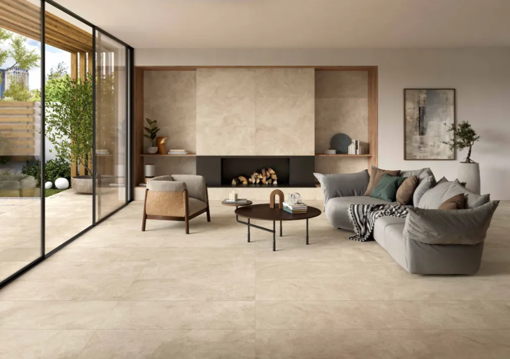 Modern living room clad in Haven Oat 24x48 beige stone-look porcelain floor tiles with a matching floor-to-ceiling fireplace feature wall.
