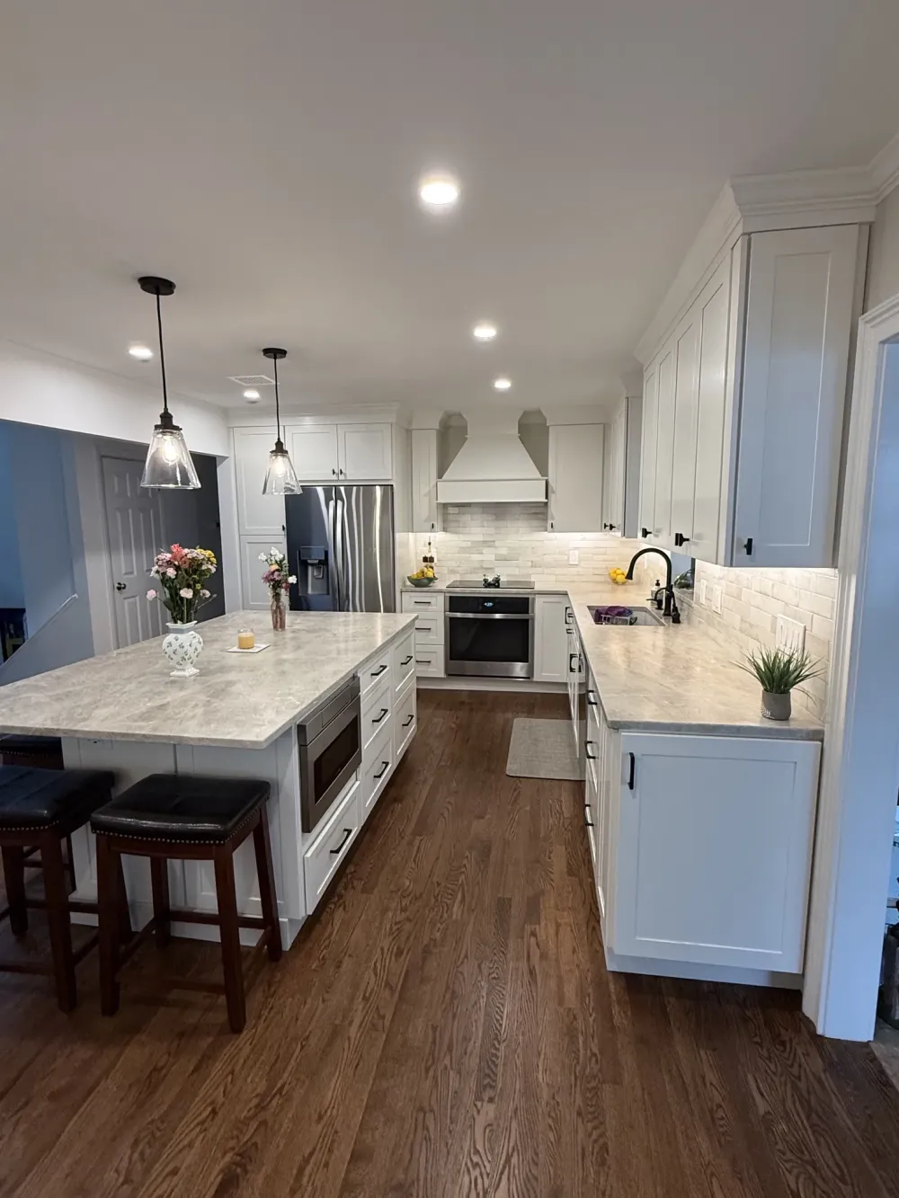 Bright kitchen showcasing a main backsplash of Craft Off-White Glossy Deco tile and an accent feature wall over the stove in Agate Bari 1x4 Pearl Herringbone mosaic tile.