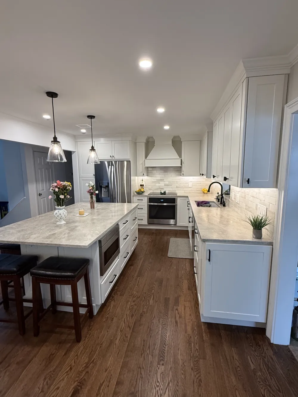 Bright kitchen showcasing a main backsplash of Craft Off-White Glossy Deco tile and an accent feature wall over the stove in Agate Bari 1x4 Pearl Herringbone mosaic tile.