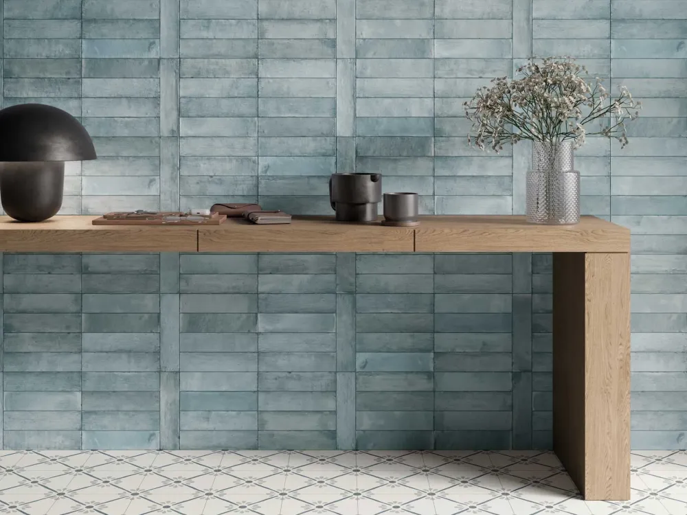 Feature accent wall displaying Laguna Blue weathered teal subway-style wall tiles installed in a geometric grid basketweave layout behind a wooden console table.