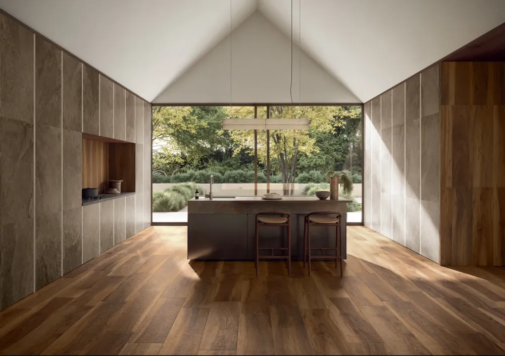 Luxury architectural kitchen featuring rich walnut-toned Oak Lane Noce Massello wood-look porcelain floor tile planks and large-format wall panels.
