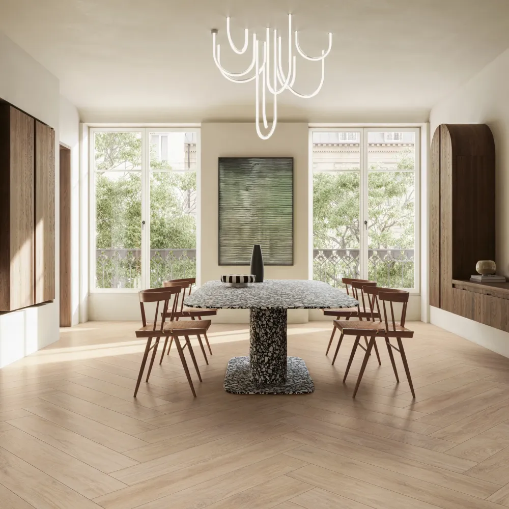 Modern dining room showcasing Oak Lane Olmo light wood-look porcelain planks installed in a timeless herringbone floor pattern.