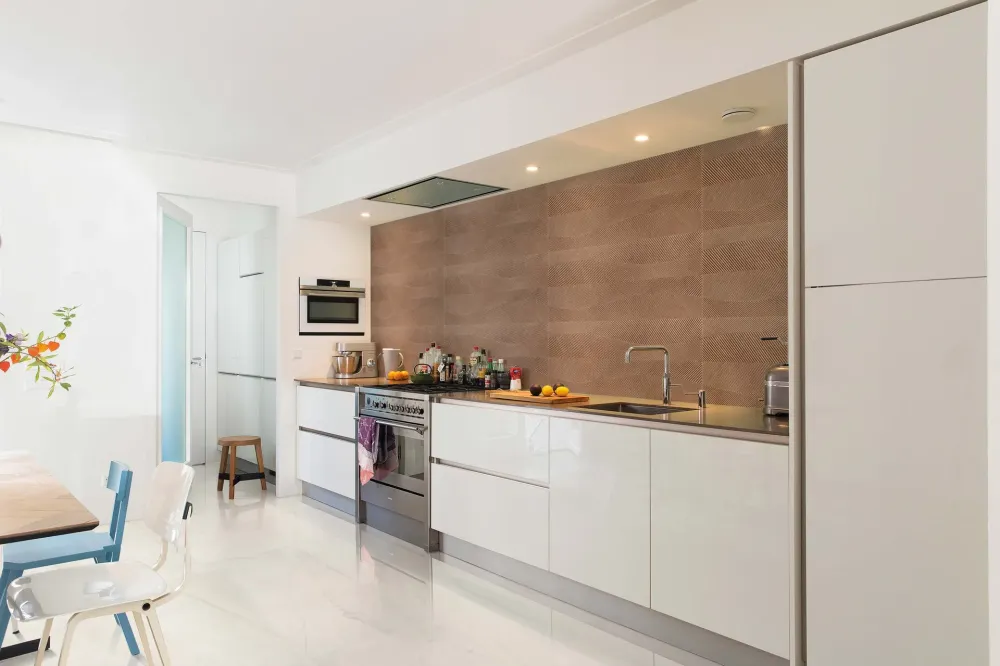 Modern minimalist kitchen featuring Mood Wall Betula Clara Origens large-format warm wood-look porcelain wall tiles as a full height backsplash.
