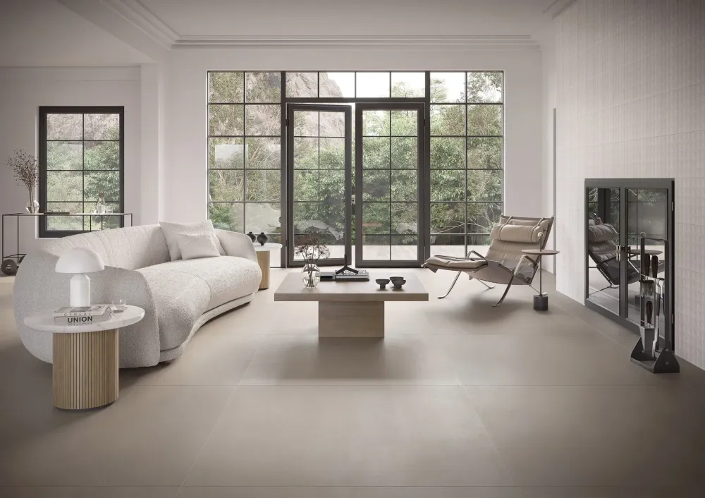Contemporary living room displaying Oh!Take Moon large-format soft grey floor tiles and a textured neutral tiled fireplace surround.