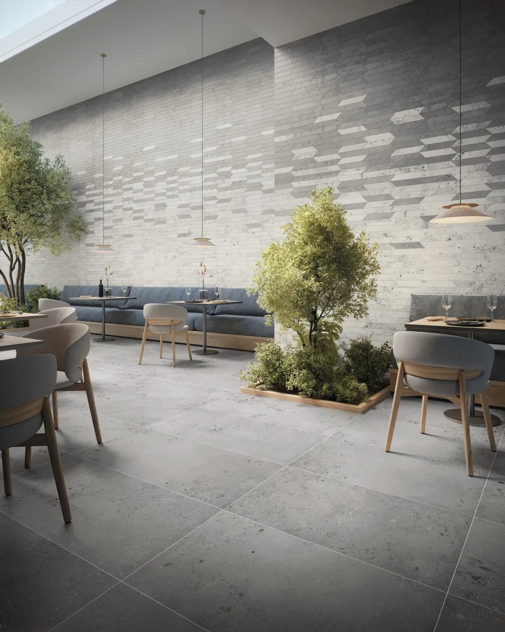 Commercial restaurant atrium featuring Lab Ash 24x48 concrete-look porcelain floor tile with a dual-tone chevron mosaic accent wall.
