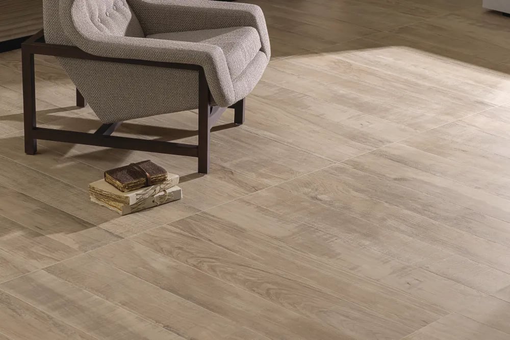 Living room floor clad in Arca Nordic 8x48 natural oak wood-look porcelain planks beside a textured armchair.