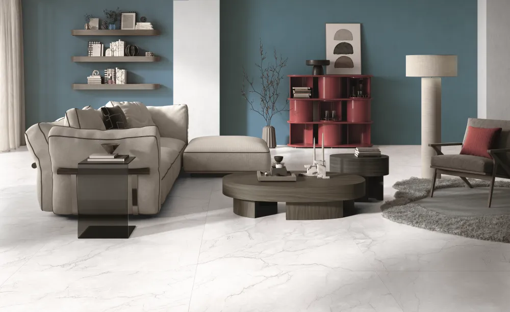 Modern living room featuring Sagrada Ghiaccio white marble-look porcelain floor tiles with subtle grey veining and a beige sectional sofa.