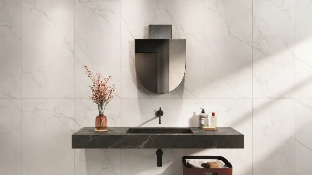 Luxury bathroom wall clad in Sagrada Ghiaccio white marble porcelain tile behind a floating Moro dark marble porcelain vanity with black fixtures.