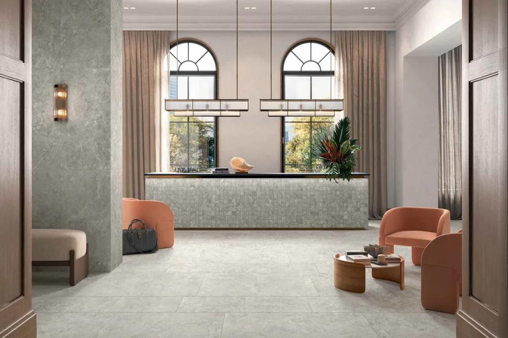 Luxury hotel lobby featuring Select Savoy White stone-look porcelain floor tiles and matching mosaic tile reception desk.