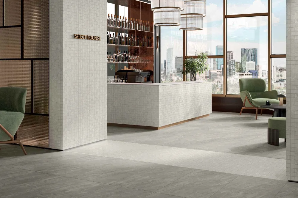 High-end cocktail lounge featuring Select Vanta Gray dark stone-look porcelain floor tiles and an off-white mosaic bar front.