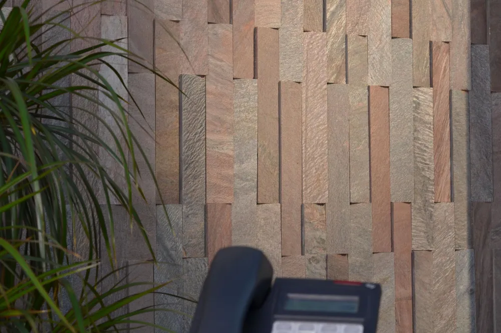 Close-up of copper-toned slate dimensional wall cladding with textured natural stone variation.