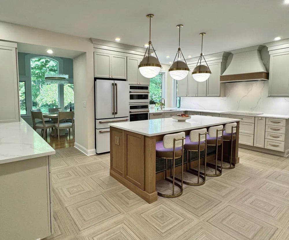 Modern kitchen floor featuring Bambusa Crema 24x24 parquet-patterned bamboo-look porcelain tile under a wooden island with brass pendant lights