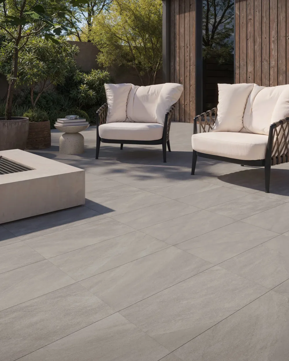 Luxury backyard patio featuring Thera Ash Exterior large-format light grey stone-look porcelain tile flooring.