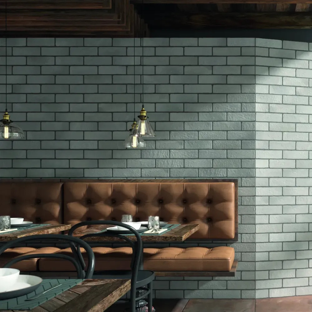 Restaurant dining area showcasing a floor-to-ceiling brick veneer accent wall featuring Tuscan Brick Greige porcelain tiles.