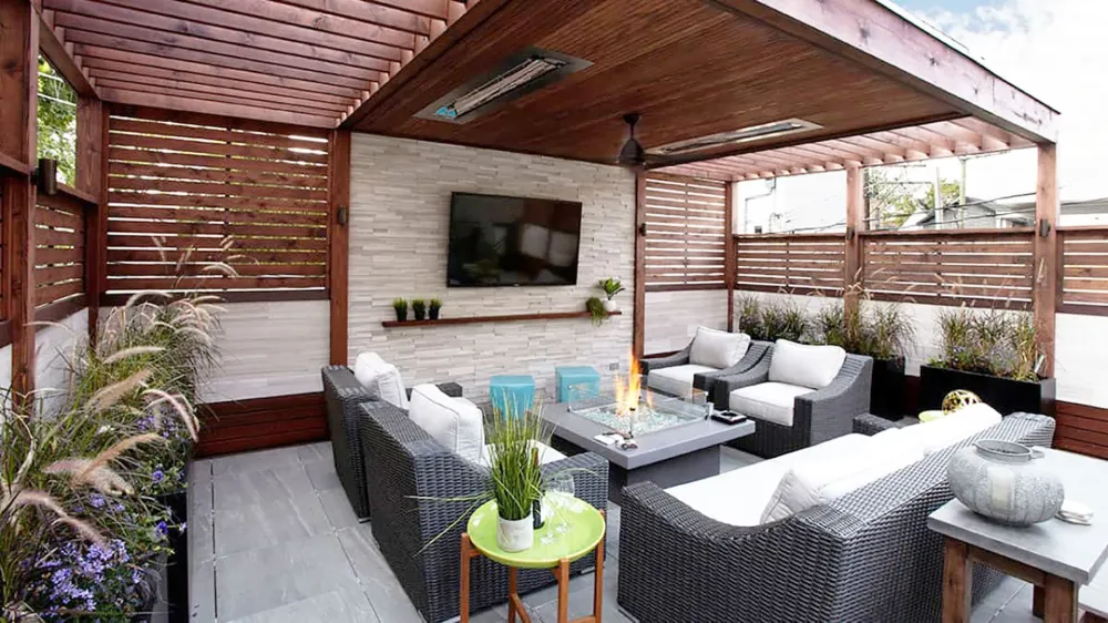 Covered patio with White Birch Honed stone wall cladding, outdoor seating, fireplace table, and wood pergola.