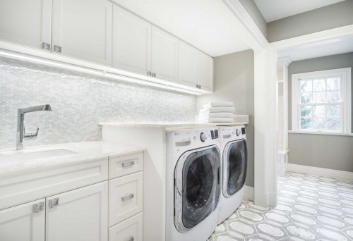 White Laundry room with a scallop mosaic and hexagon style floor all in natural stone.